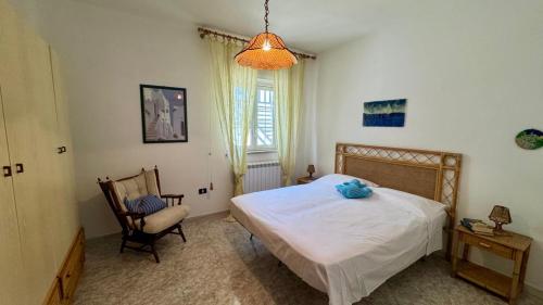 a bedroom with a bed and a chair and a window at Villa Ciaky in Leporano Marina