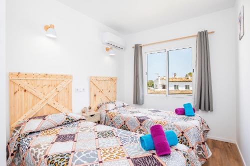 a bedroom with two beds and a window at Gran Sol Family 7 in Felanitx