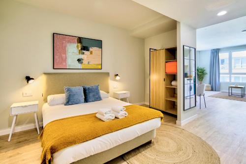 a bedroom with a bed with towels on it at Apartamentos Olivia by gaiarooms in Bilbao