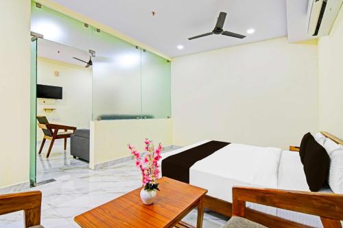 a bedroom with a bed and a table with flowers on it at Townhouse Oak Dwarakanagar Port Stadium in Maddilapālem