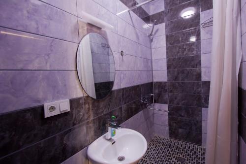 La salle de bains est pourvue d'un lavabo et d'un miroir. dans l'établissement Center Hotel, à Bishkek