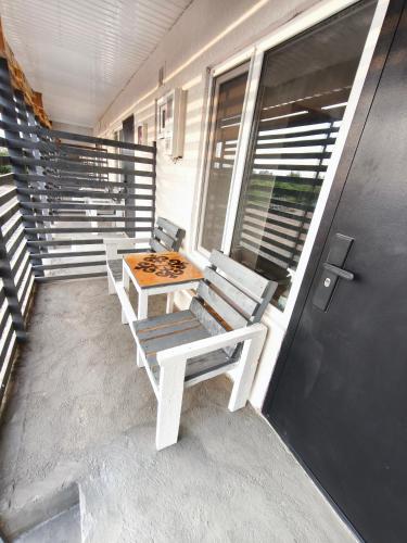 a porch with two benches and a table and a door at Meymandos in Tossor