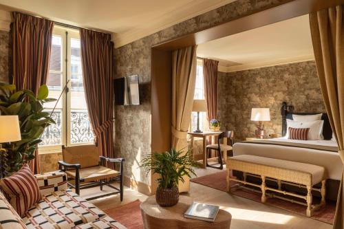 une chambre avec un lit et un salon dans l'établissement Hôtel Aubépine, à Paris