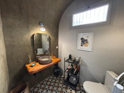une salle de bain avec un lavabo et un miroir dans l'établissement Maison de Caractère au coeur du village, à Castifao