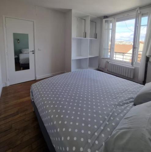 une chambre blanche avec un grand lit avec une fenêtre dans l'établissement Appartement Cosy 3 chambres - Proche de Paris, à Arcueil