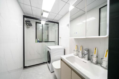 Un baño blanco con inodoro y lavabo. en Downtown, 2BR 1LR 1KT 1BA, near Pedestrian St, the Bund, Pearl Tower, en Shanghái