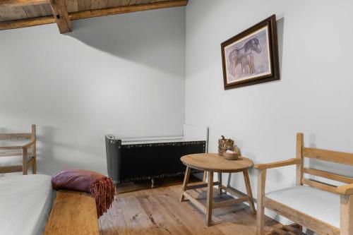a living room with a tv and a table and a chair at Ter Winterbeke op een steenworp van Poperinge in Poperinge