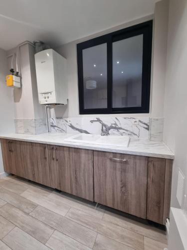 une salle de bain avec un lavabo et une fenêtre dans l'établissement Appartement Cosy 3 chambres - Proche de Paris, à Arcueil