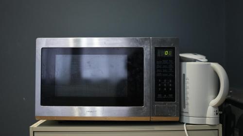 a microwave oven sitting on top of a table at Apartment & Rooms in London in Croydon