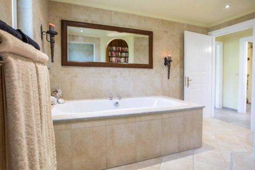 a large bathroom with a tub and a mirror at Villa Octavius in Ráchi
