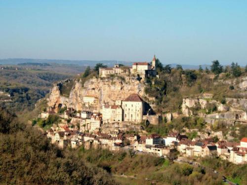 a village on a hill with a castle on it at Slate-Roofed Hideaway in Cressensac
