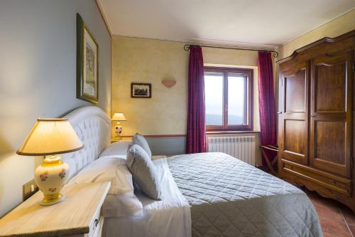 a bedroom with a bed and a table with a lamp at Il Melograno Agriturismo & SPA in Pianello