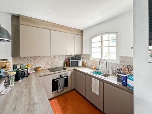 une cuisine avec des armoires blanches et un évier dans l'établissement Maison de Pêcheur à Port Grimaud 2, à Grimaud