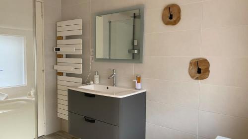 une salle de bain avec un lavabo et un miroir dans l'établissement Villa, à Hourtin