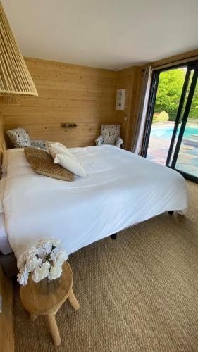 un grand lit blanc dans une chambre avec une fenêtre dans l'établissement Villa, à Hourtin