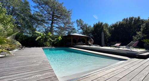 - une piscine avec une terrasse et un kiosque dans l'établissement Villa, à Hourtin