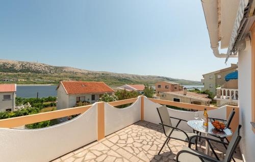 パグにあるNice Apartment In Pag With Wifiの建物の上にテーブルと椅子が置かれたバルコニー