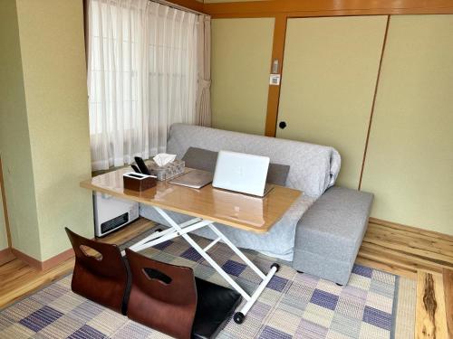 a room with a desk with a laptop on it at 和宿 湯沢チャオ Wayado Yuzawa Ciao in Yuzawa