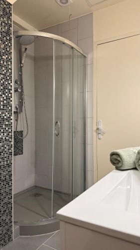 une douche avec une porte vitrée dans une salle de bain dans l'établissement Tout confort 6 personnes - Proche de Disney, à Claye-Souilly