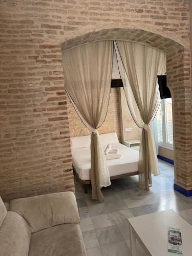 a bedroom with a bed and a brick wall at Philippe's Home Triana in Seville
