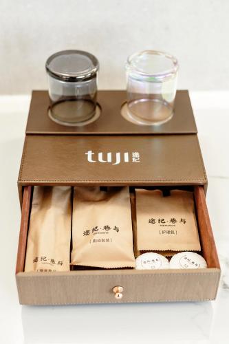a wooden box with two glasses and two bowls at Tuji Lane and Fanghe Homestay (West Street Kaiyuan Temple Branch) in Quanzhou