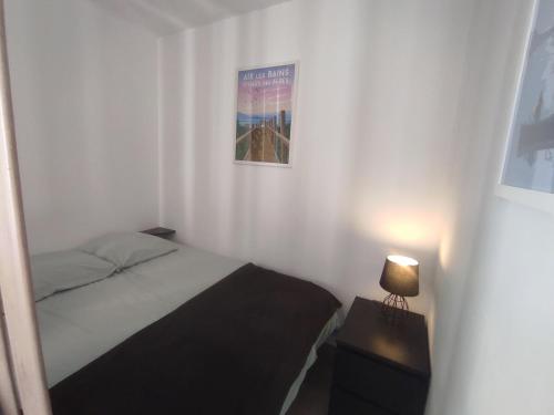 - une petite chambre avec un lit et une lampe dans l'établissement Studio 25 m2 l'Aix'quise, hyper centre-ville, balcon, à Aix-les-Bains