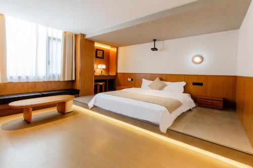 a bedroom with a large white bed and a table at Tuji Lane and Fanghe Homestay (West Street Kaiyuan Temple Branch) in Quanzhou