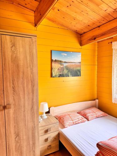 a bedroom with yellow walls and a bed in a room at Stacja Lato domki dla rodzin z dziećmi in Mikołajki