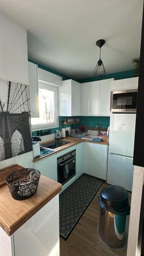 une cuisine avec des armoires blanches et un four à plaques de cuisson dans l'établissement Le Cosy Dôme, à Cenon