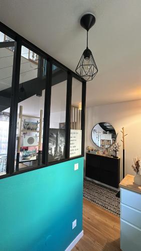 un salon avec un mur bleu et une suspension dans l'établissement Le Cosy Dôme, à Cenon