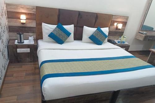 a bedroom with a large bed with blue and white pillows at HOTEL SINGH CONTINETAL in New Delhi