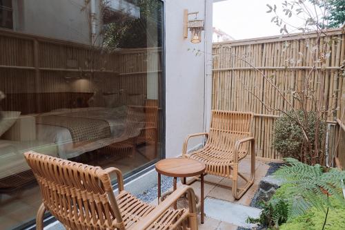 a patio with two chairs and a table and a bed at Tuji Lane and Fanghe Homestay (West Street Kaiyuan Temple Branch) in Quanzhou