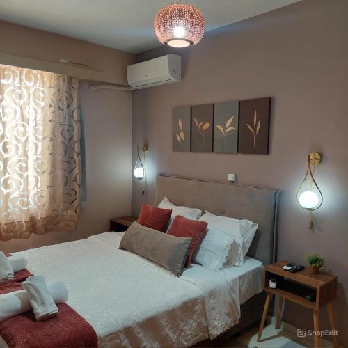 a bedroom with a large white bed with red pillows at La Dolce Vita in Chalkida