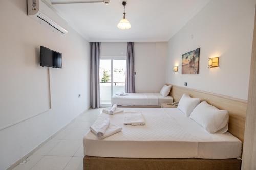 a hotel room with a bed and a tv at Bayram Hotel in Çeşme