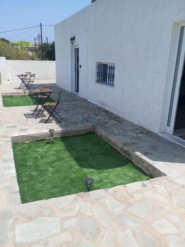 a small yard with grass in front of a building at Kyriaki's Studio Aigina in Souvala