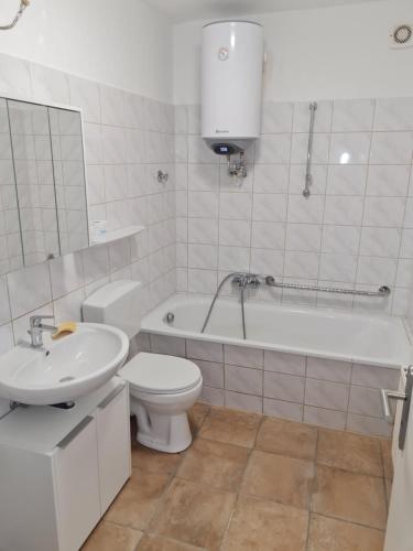 a white bathroom with a toilet and a sink at Ferienwohnung am Schloss in Eckartsberga