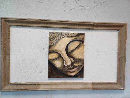 a painting of a face in a frame on a wall at Ebner Pince - Panzió in Turbékpuszta