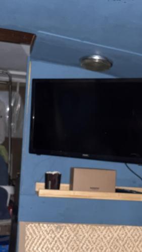 a blue box with a tv on a table at Docked boat in Le Barcarès