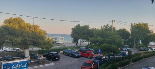 a group of cars parked in a parking lot near the ocean at Beachfront vision 2 in Artemida