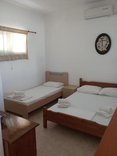 a room with two beds and a window at Kyriaki's Studio Aigina in Souvala