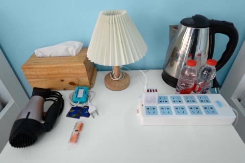 a table with a coffee maker and a lamp on it at Dive & Dwell Tulamben in Tulamben
