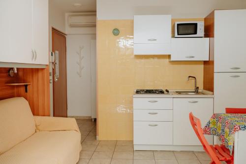 a small kitchen with white cabinets and a microwave at Residenza Alpaluba in Vasto