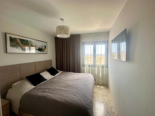 a bedroom with a bed and a large window at Seaside Two Bedroom Apartment in Los Cristianos