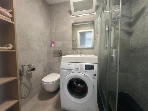 a bathroom with a washing machine and a toilet at Seaside Two Bedroom Apartment in Los Cristianos