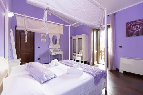 a purple bedroom with a bed with a canopy at Villa Flo' - Piscina Privata, Relax & Privacy in Manciano