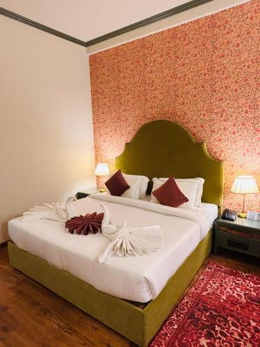 a bedroom with a large bed with white sheets at Hotel Kamal Palace in Jalandhar