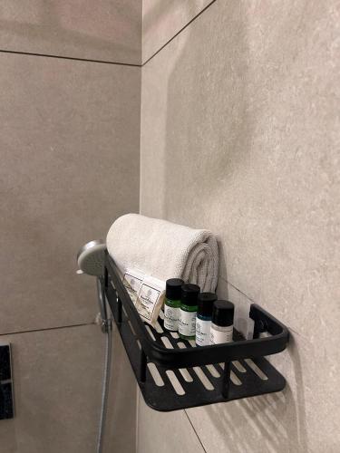 a shelf in a bathroom with five bottles on it at Hotel Kamal Palace in Jalandhar