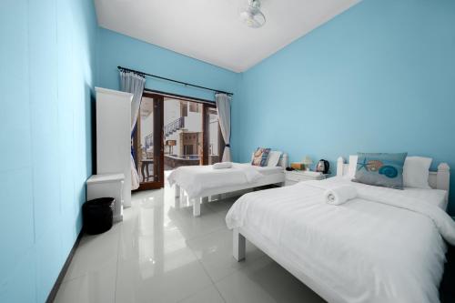 two beds in a room with blue walls at Dive & Dwell Tulamben in Tulamben