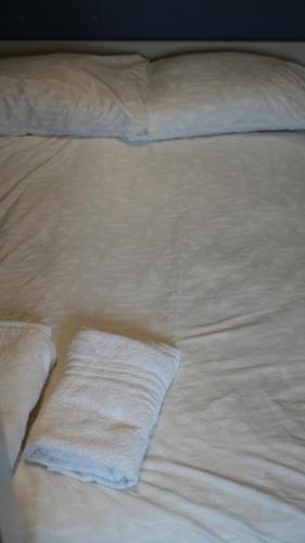 a white bed with white sheets and pillows at Apartment & Rooms in London in Croydon