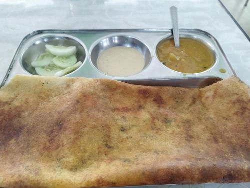 a plate of food with a pita sandwich and dipping sauce at Sheetal Restaurant in Mussoorie